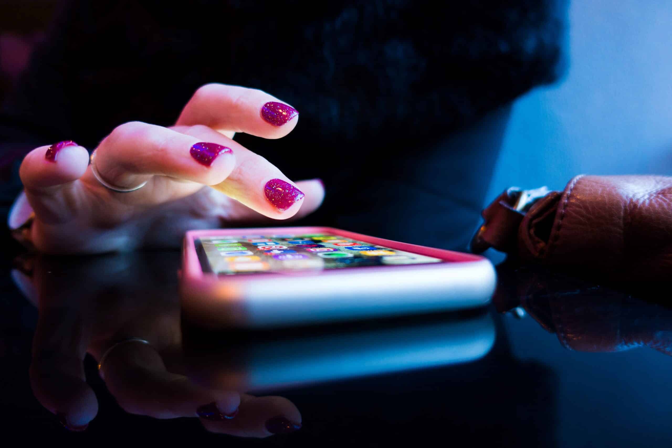 person using black smartphone with gray and pink case